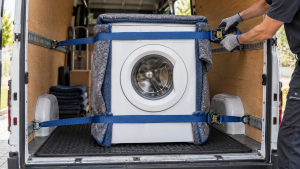 Waschmaschine wird im Kleintransporter für einen Umzug gesichert